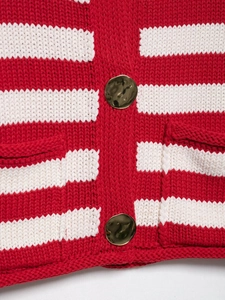 Close-up of golden hammered metal buttons and red white striped knit texture