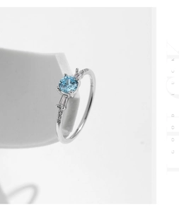 Macro shot of S925 silver ring featuring blue center stone and side baguette diamonds