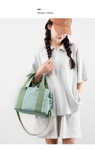 Detailed shot of mint green canvas tote bag showing top handles and metal strap hooks