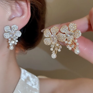Macro shot of silver zircon flower earrings with pearl drop and rectangle main stone