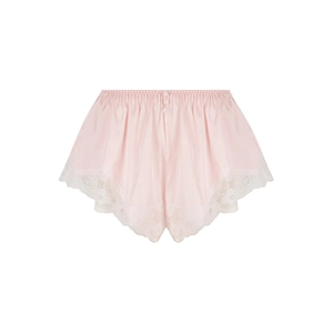 Detailansicht der rosa Satin-Schlafshorts mit weißem Spitzenbesatz und Zierknöpfen