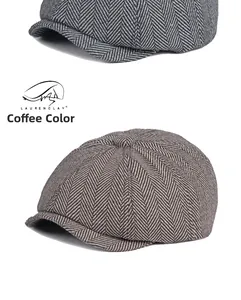 Detail of grey and coffee herringbone newsboy caps showing the wool-like tweed texture