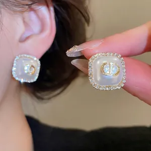 Elegant square stud earrings with pearl center, gold CD initials and crystal border