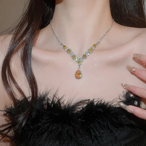 Detail of silver necklace with pear-cut yellow gemstone and sparkling zircon crystals