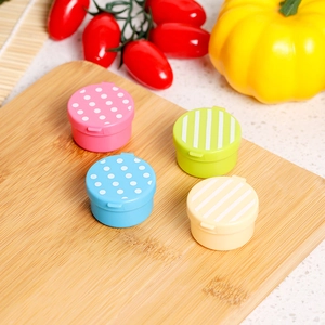 Close-up of portable mini sauce containers with animal cartoon patterns on a wooden board