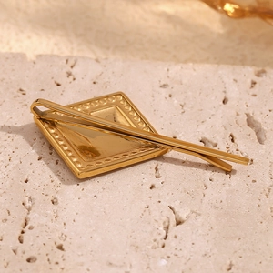 Détail d'une pince à cheveux géométrique plaquée or 18K avec bords diamants sur pierre