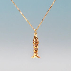 Detailed shot of a gold-plated articulated koi fish pendant with flexible metal joints