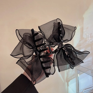 Detailed view of an elegant black lace mesh bow hair claw clip for bun hairstyles