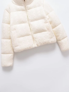 Close-up of knit cable-quilted texture on women's off-white insulated zip jacket