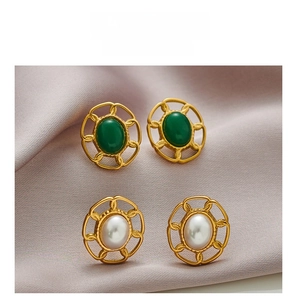 Vue détaillée des boucles d'oreilles ovales en perle et turquoise en acier plaqué or