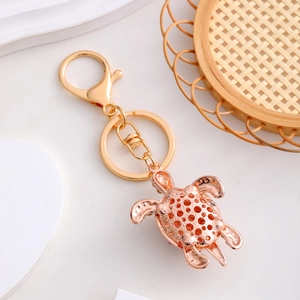 Sparkling crystal sea turtle keychain in rose gold metal with hollow honeycomb shell design