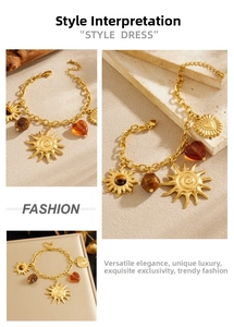 Macro shot of gold-plated sun and tiger eye stone charms on beaded chain bracelet