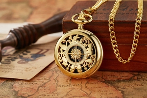 Macro shot of golden vintage pocket watch compass on an old map background
