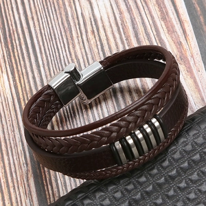 Close-up of multilayer braided leather bracelet with silver rings and magnetic clasp