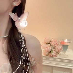 Detail of pink mesh butterfly hair clip with elegant pearl tassels on a model