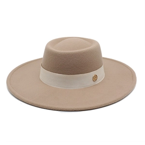 Detail of wool fedora hat featuring a gold M-letter buckle and silk ribbon trim