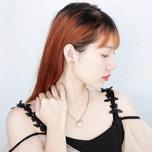 Gros plan d'un collier avec pendentif cœur en or rose et boucles d'oreilles assorties