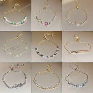 Close-up of adjustable bracelets with colorful zircons in gold and silver finishes