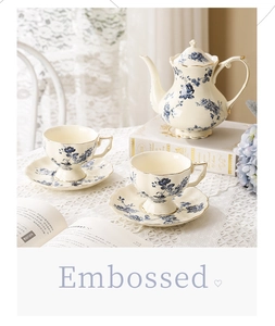 Gros plan sur théière et tasses en céramique vintage avec motifs floraux bleus et dorure