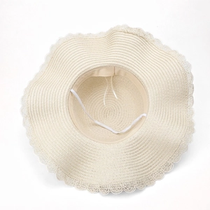 Elegant summer straw sun hat with large wavy brim and delicate lace trim detail
