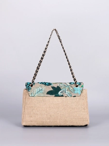 Detail of embroidered floral sequins and metallic chain strap on woven linen bag