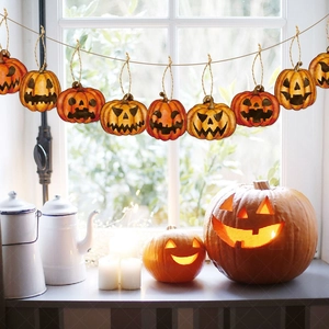 Halloween pumpkin banner decorations with diverse expressions hanging by the window
