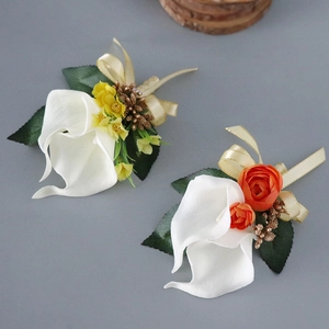 Calla lily wedding boutonnieres with white petals and elegant gold ribbon accents