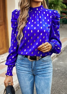Detailed view of puff sleeves and elastic cuffs on a royal blue leaf print blouse