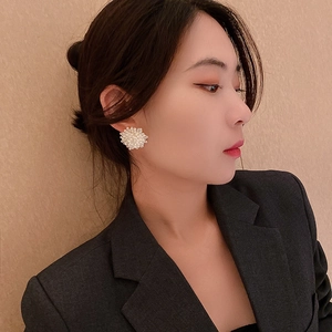 Elegant white pearl flower cluster stud earrings for women shown on a model