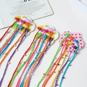 Close-up of colorful braided hair extensions with clips and beads for kids hair styling