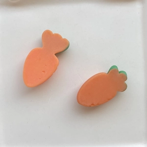 Macro shot of two orange resin carrot charms for DIY hair clips and fridge magnets