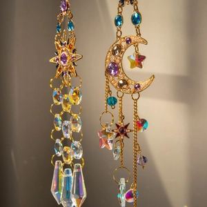 Close-up of golden sun and moon suncatcher with colorful crystals and star charms