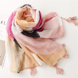 Close-up of geometric pattern scarf featuring pink tassel trim and light fabric texture