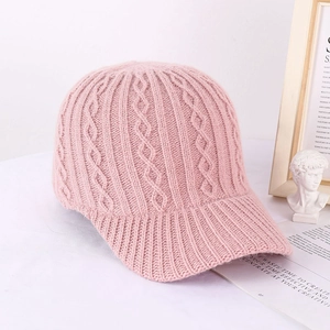 Detailed macro shot of pink cable knit baseball cap showing soft yarn texture and pattern
