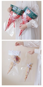 Close-up of Christmas gift bag with Santa Claus prints and elegant ribbon handles