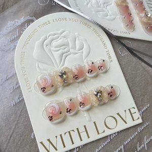 Macro detail of French press-on nails with 3D resin bows and sparkling rhinestones