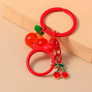 Detail of red cherry charms and metallic ring on professional studio background