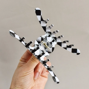 Close-up of black and white checkered hair claw clip with strong metal spring detail