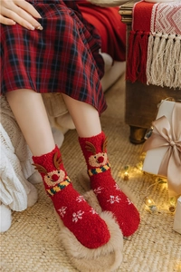 Detail of red Christmas coral fleece socks with 3D reindeer ears and snowflake patterns