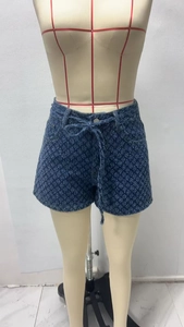 Détail du short en jean bleu foncé à taille haute avec imprimé floral et cordon réglable