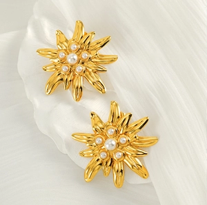 Gros plan détaillé de boucles d'oreilles fleuries dorées à l'or 18 carats avec perles