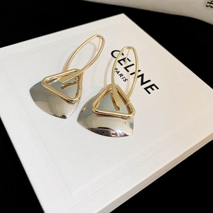 Detail of geometric triangle drop earrings in gold and silver mixed finish on display