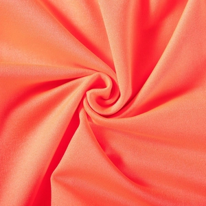 Macro detail of vibrant orange elastic fabric showing fine knit texture and soft sheen