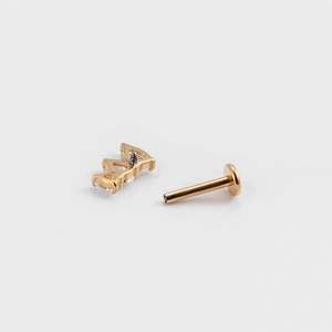Detail of G23 titanium flat back stud featuring three clear zircon gemstones in gold finish