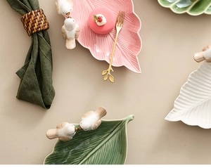 Detailed top view of leaf-shaped ceramic plates with small bird accents and glaze finish