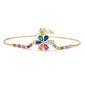 Dettaglio del braccialetto dorato con fiore in zircone colorato e catena regolabile
