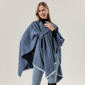 Close-up of blue cashmere shawl with white fringe and elegant knot-tie design detail