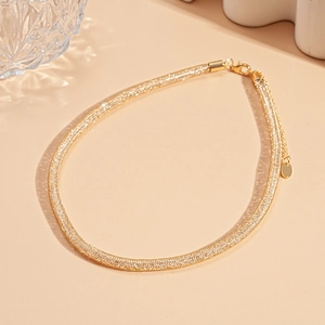 Detailed shot of golden mesh chain necklace with lobster clasp and extension link