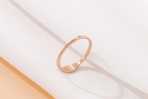 Detailed view of thin rose gold titanium ring with a flat signet on white silk