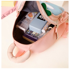 Detailed interior view of a pink kids backpack showing spacious storage for school supplies